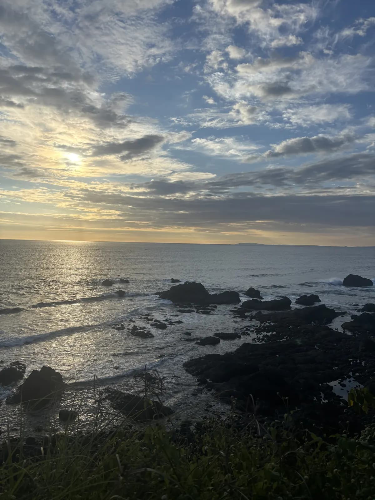 Rocky shoreline under a soft sky